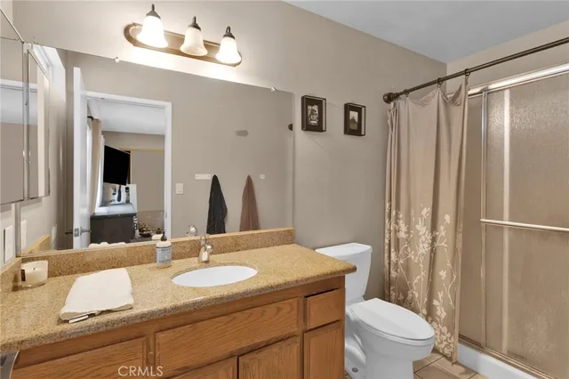 a bathroom with a granite countertop sink a toilet and a mirror
