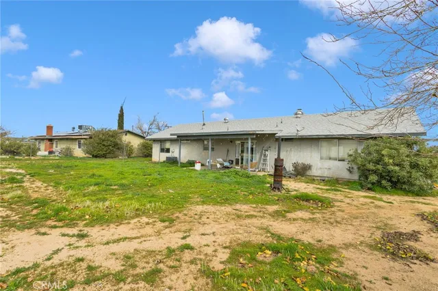 a view of a house with backyard and sitting area