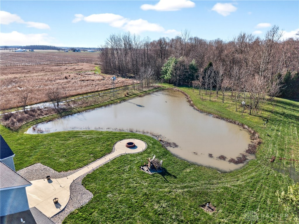 6560 Snyder Road Fletcher, OH 45326 - Photo 58 of 71 This expansive outdoor space features a tranquil pond and a inviting patio area, perfect for relaxation.