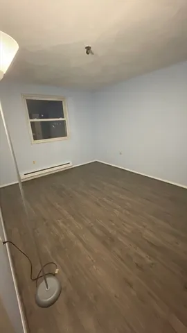 an empty room with wooden floor and mirror