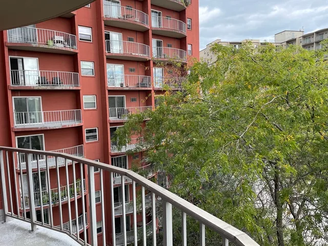 a view of a balcony with wooden floor and fence