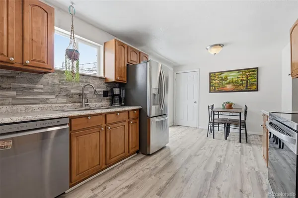 a kitchen with stainless steel appliances granite countertop wooden cabinets a stove top oven a sink and dishwasher