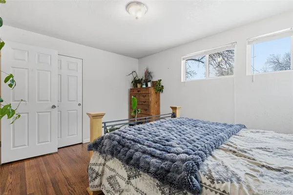 a bedroom with a bed and a wooden floor