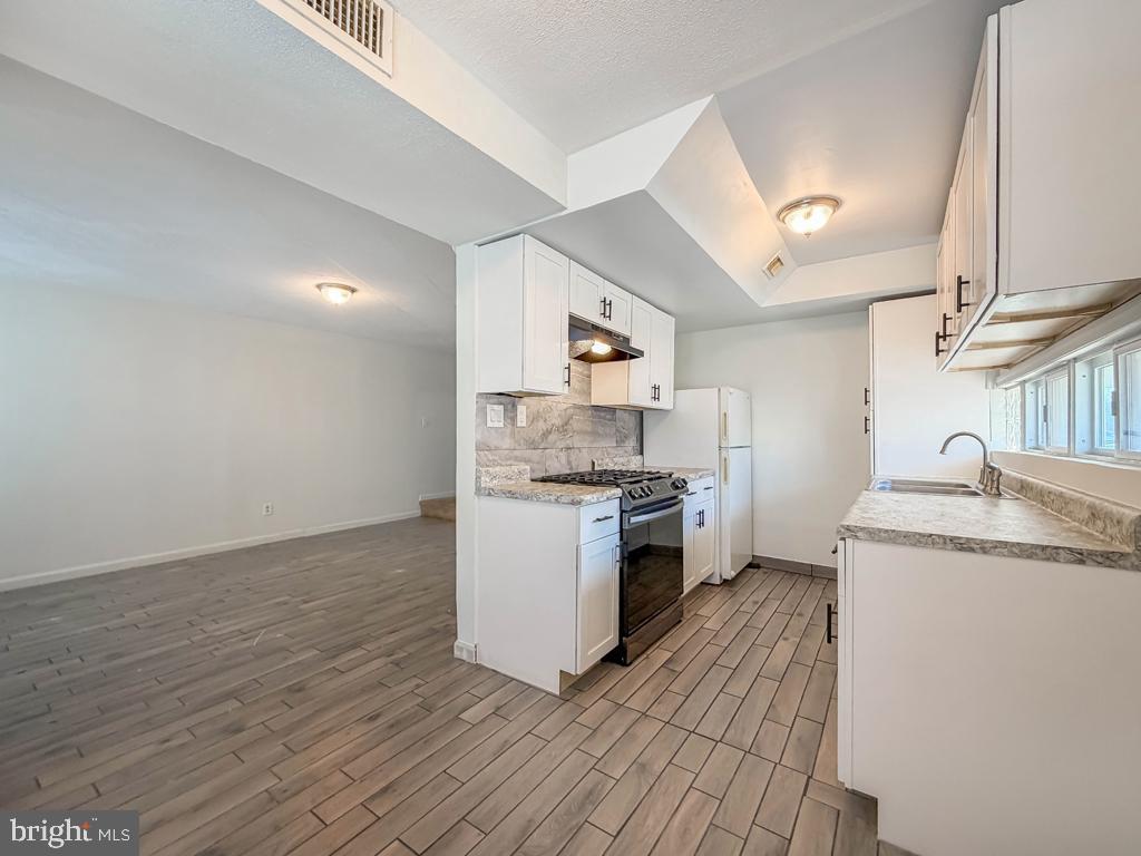 3850 Woodhaven Road, Unit 901 Philadelphia, PA 19154 - Photo 12 of 24 a kitchen with granite countertop a sink and a stove top oven