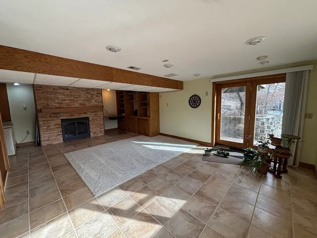 an empty room with windows and fireplace
