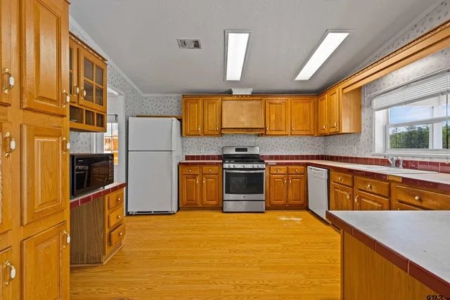 a kitchen with stainless steel appliances granite countertop a stove a sink and a refrigerator