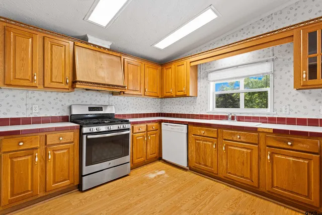 a kitchen with stainless steel appliances granite countertop a sink and cabinets