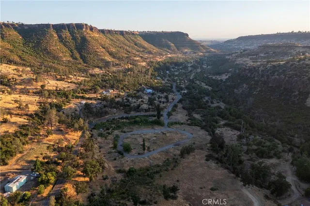 a view of a dry yard with mountains in the background