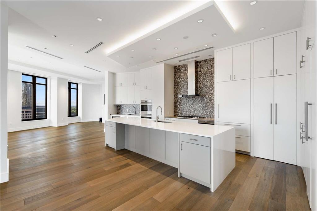 3376 Peachtree Road Northeast, Unit 33B Atlanta, GA 30326 - Photo 11 of 45 a large white kitchen with lots of counter space and wooden floor