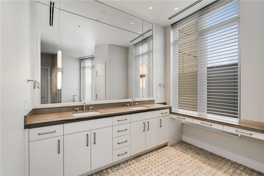 3376 Peachtree Road Northeast, Unit 33B Atlanta, GA 30326 - Photo 24 of 45 a bathroom with a sink mirror and a bathtub next to a window