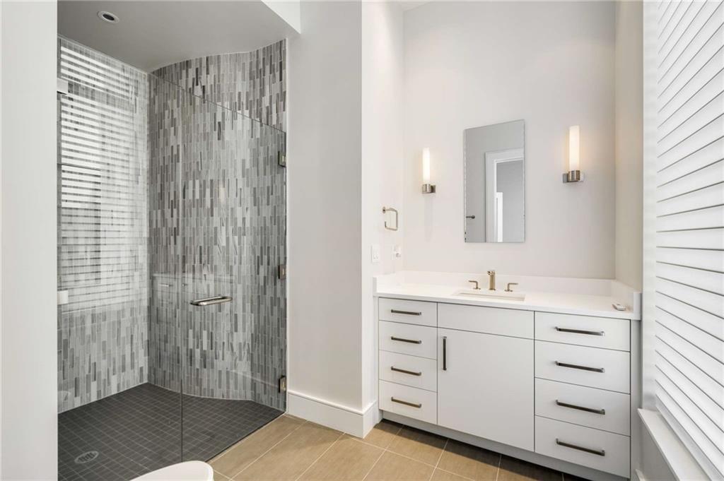 3376 Peachtree Road Northeast, Unit 33B Atlanta, GA 30326 - Photo 30 of 45 a bathroom with a double vanity sink a mirror and a shower