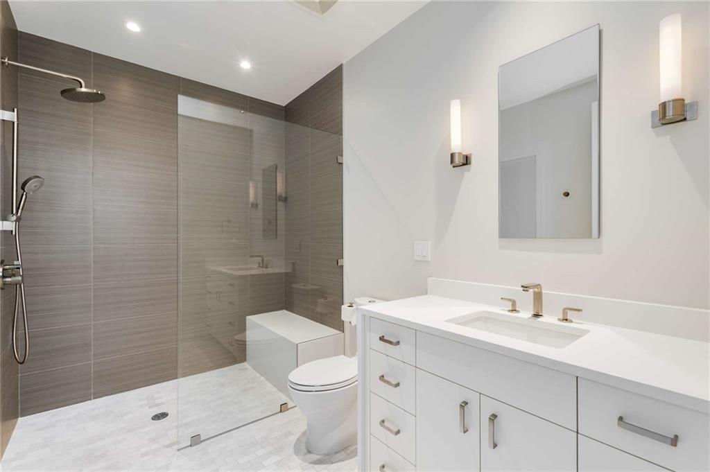 3376 Peachtree Road Northeast, Unit 33B Atlanta, GA 30326 - Photo 33 of 45 a bathroom with a sink a toilet a mirror and shower