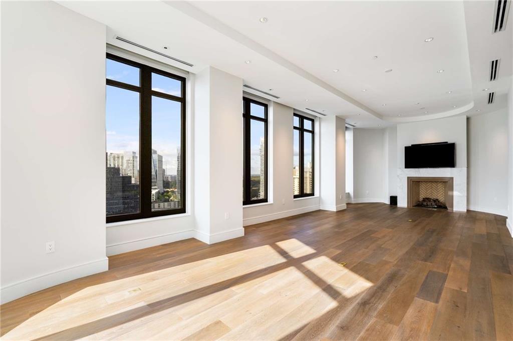 3376 Peachtree Road Northeast, Unit 33B Atlanta, GA 30326 - Photo 4 of 45 a view of a livingroom with wooden floor and a flat screen tv