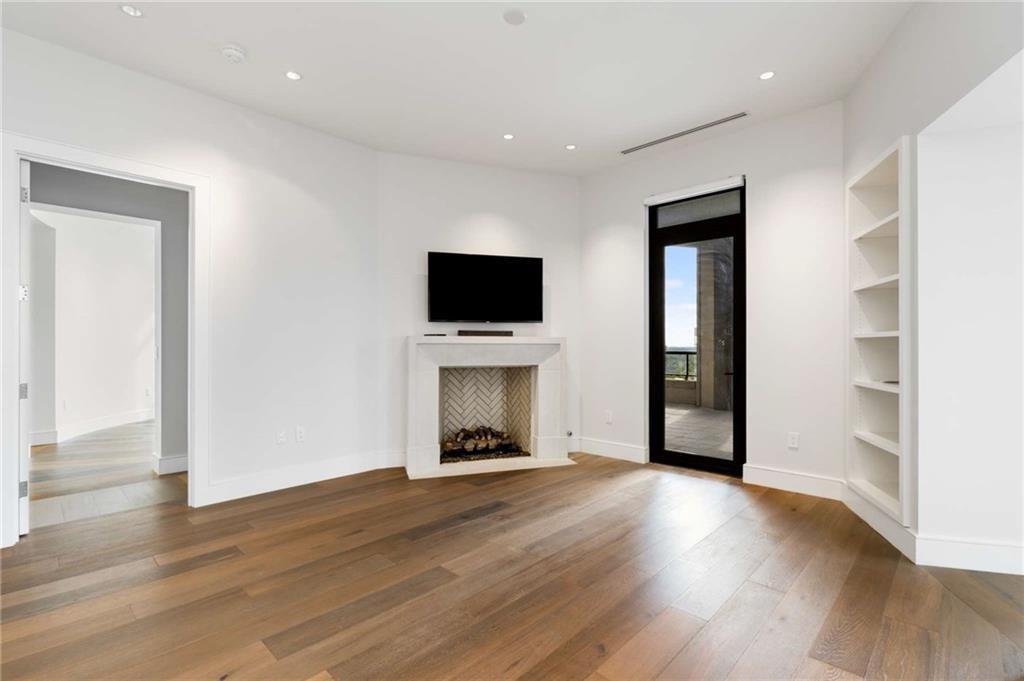 3376 Peachtree Road Northeast, Unit 33B Atlanta, GA 30326 - Photo 8 of 45 a view of an empty room with wooden floor a fireplace and a window