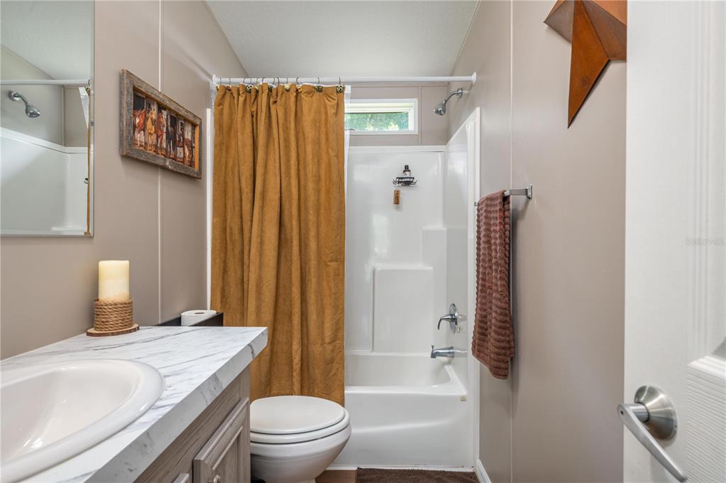 15079 Brahma Road Polk City, FL 33868 - Photo 26 of 40 a bathroom with a sink a toilet and shower