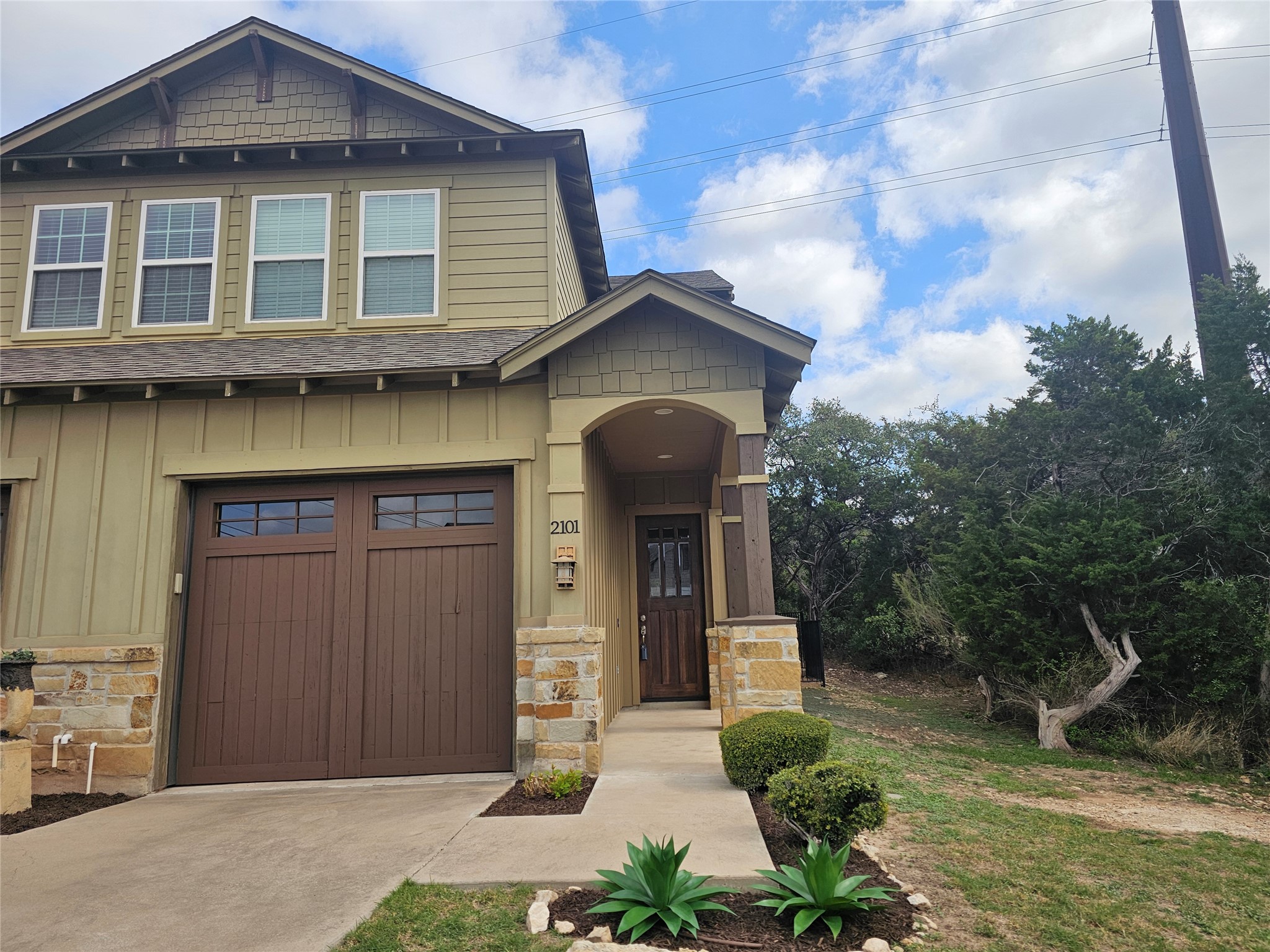 4301 Mansfield Dam Road, Unit 2101 Austin, TX 78734 - Photo 2 of 17 Craftsman-style home featuring stone siding, a shingled roof, and board and batten siding