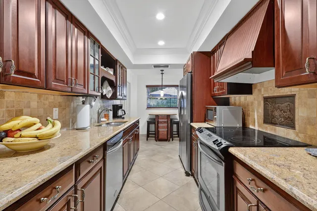 a kitchen with granite countertop a sink a stove and cabinets