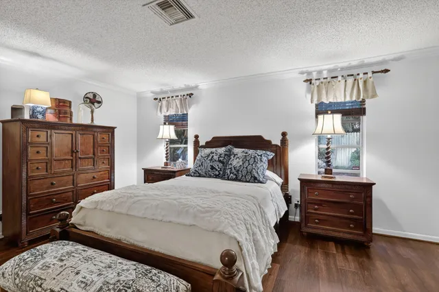 a bedroom with a bed a dresser and book shelf