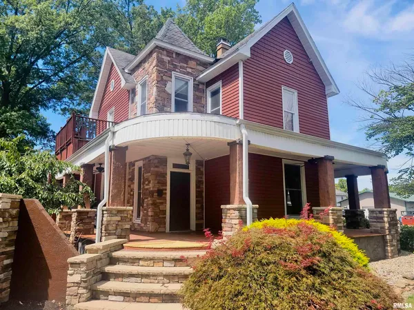 a view of a house with entrance stairs and a garden