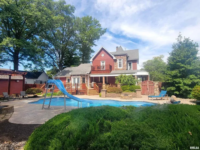 an aerial view of a house with swimming pool and porch
