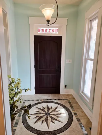 a view of a dining room with furniture a chandelier and wooden floor
