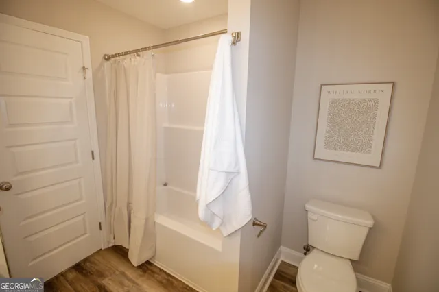 a white toilet sitting next to a shower