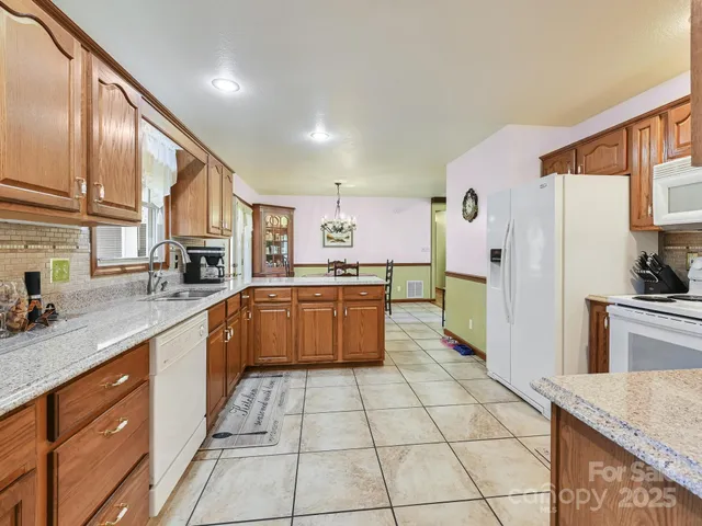 a large kitchen with stainless steel appliances granite countertop a stove a sink and a refrigerator