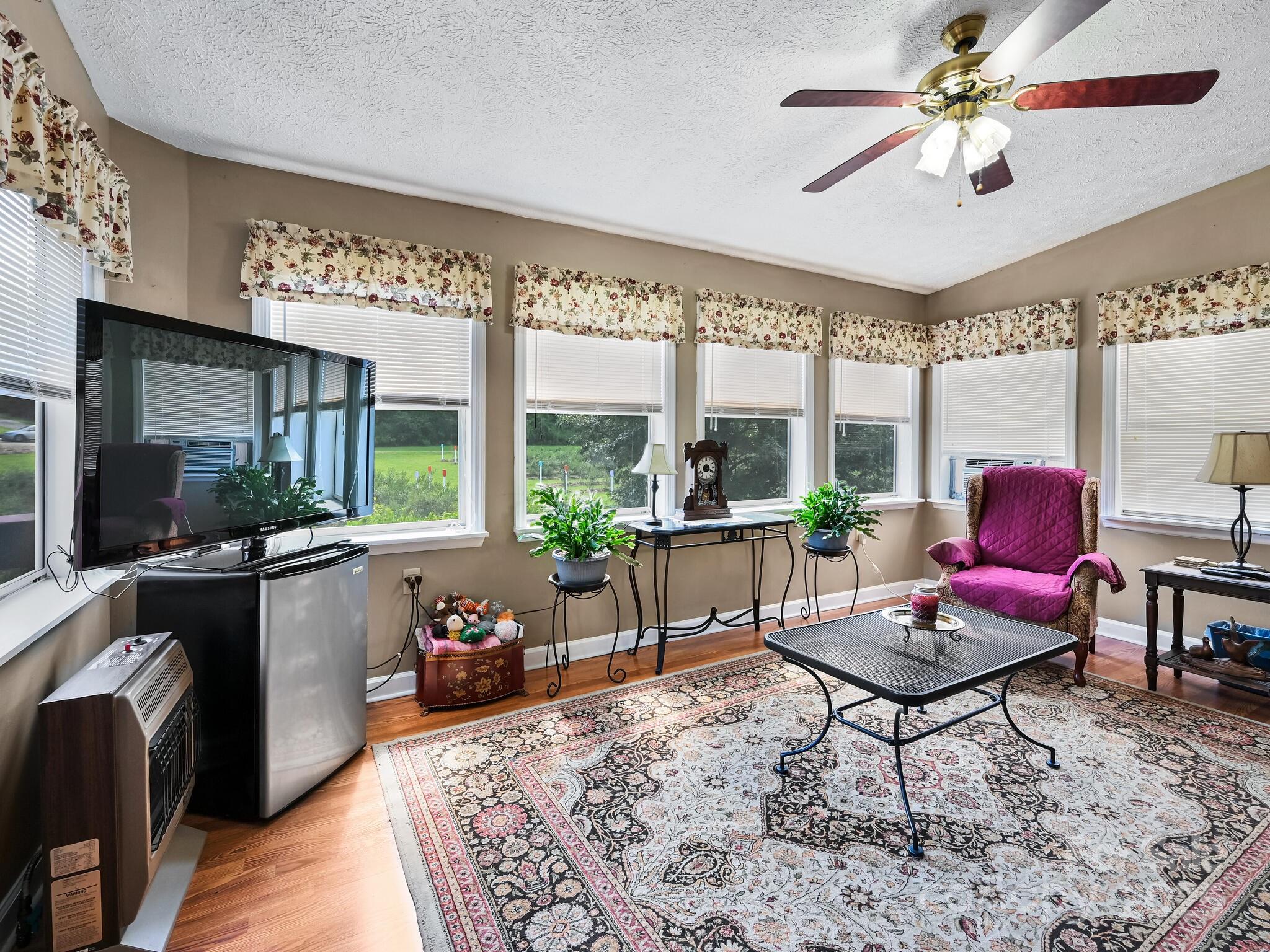 20 Brooks Cove Road Candler, NC 28715 - Photo 26 of 43 a living room with furniture a flat screen tv and a floor to ceiling window