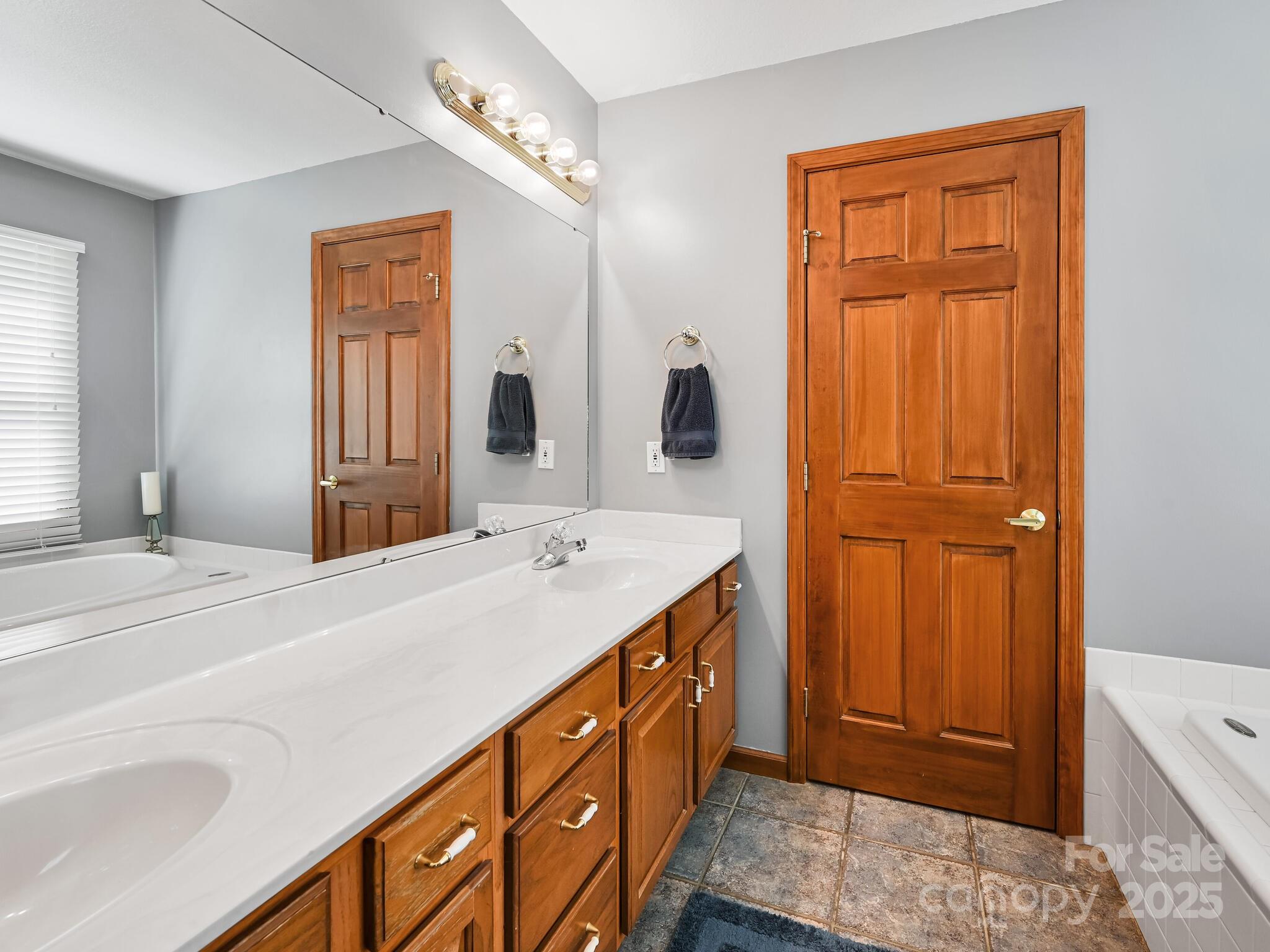 20 Brooks Cove Road Candler, NC 28715 - Photo 35 of 43 a spacious bathroom with a double vanity sink a mirror and a bathtub