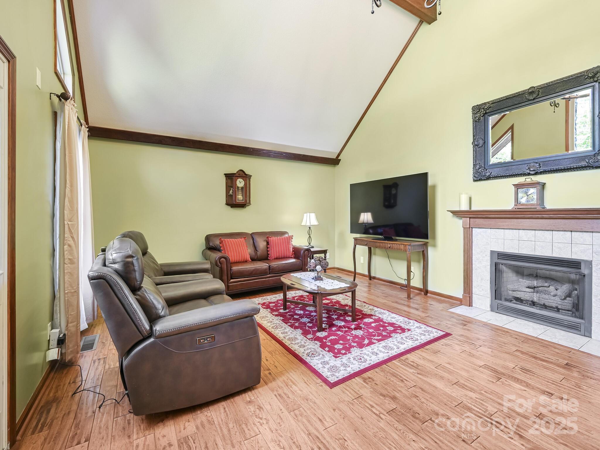 20 Brooks Cove Road Candler, NC 28715 - Photo 7 of 43 a living room with furniture a flat screen tv and a fireplace