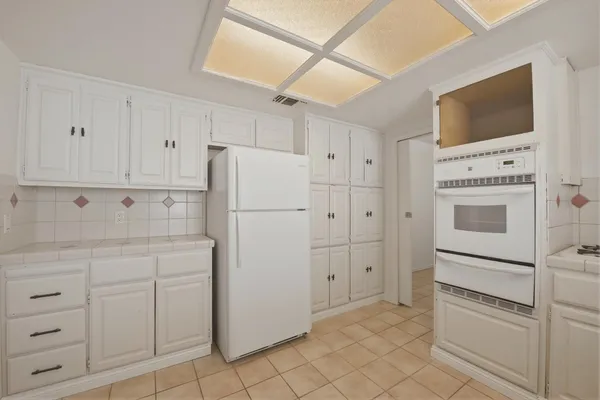a kitchen with white cabinets and white appliances