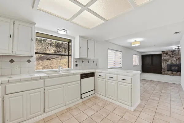 a kitchen with white cabinets a sink and appliances