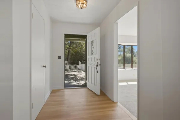 a view of a hallway with wooden floor and a livingroom