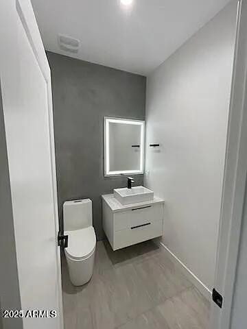 2826 North 28th Place Phoenix, AZ 85008 - Photo 4 of 8 a bathroom with a toilet a sink and mirror