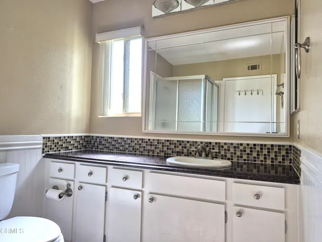 a bathroom with a sink a toilet and mirror