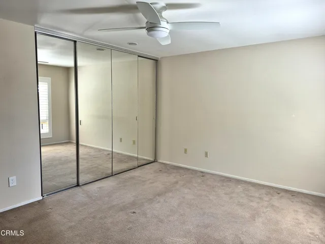 an empty room with fan and entryway