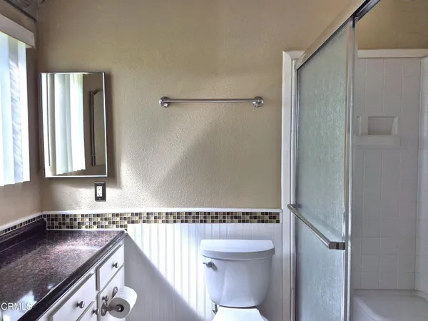 a bathroom with a granite countertop sink toilet and shower