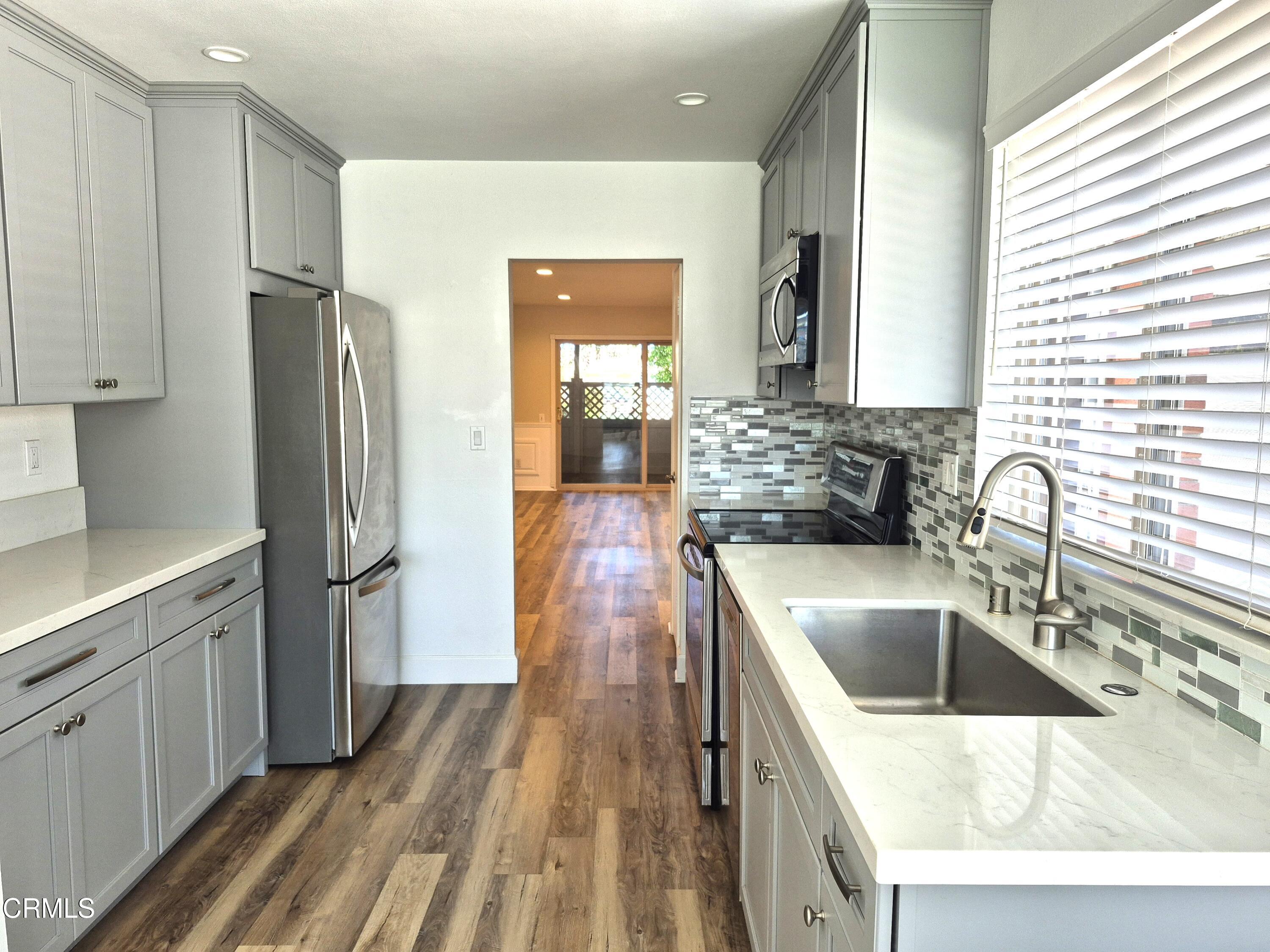 7107 Village 7 Camarillo, CA 93012 - Photo 7 of 21 a kitchen with a refrigerator sink and wooden floor