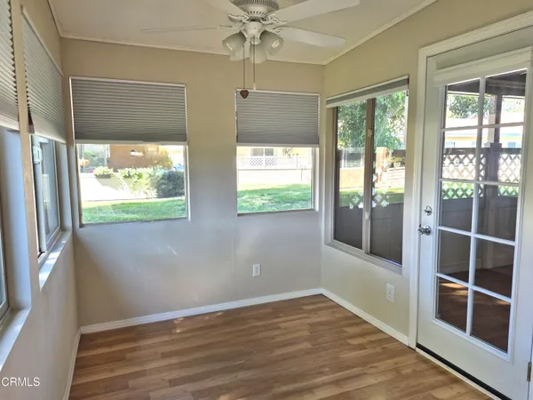 a view of an empty room with a window and wooden floor