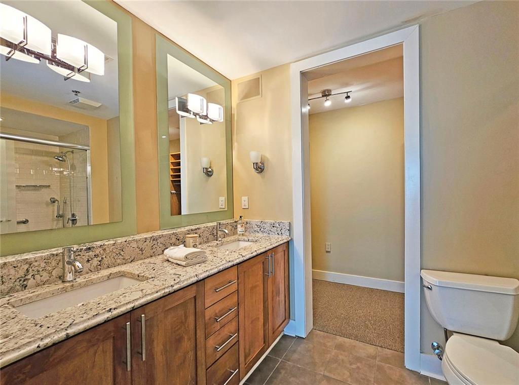 4561 Olde Perimeter Way, Unit 704 Atlanta, GA 30346 - Photo 11 of 45 a bathroom with a granite countertop sink toilet and shower