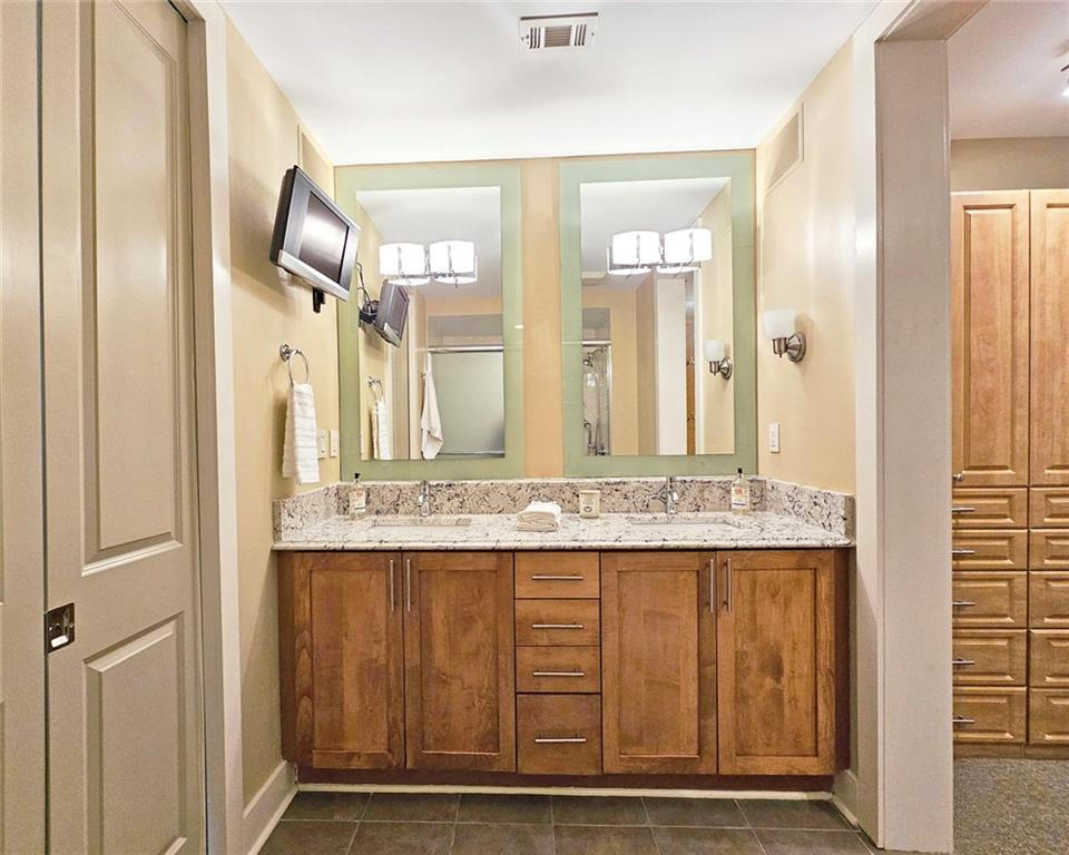 4561 Olde Perimeter Way, Unit 704 Atlanta, GA 30346 - Photo 12 of 45 a bathroom with a granite countertop sink and a mirror