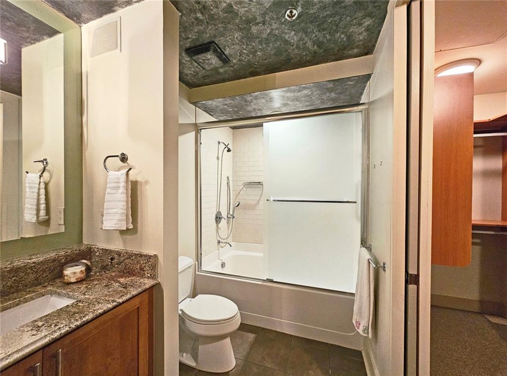 4561 Olde Perimeter Way, Unit 704 Atlanta, GA 30346 - Photo 18 of 45 a bathroom with a granite countertop sink toilet and shower