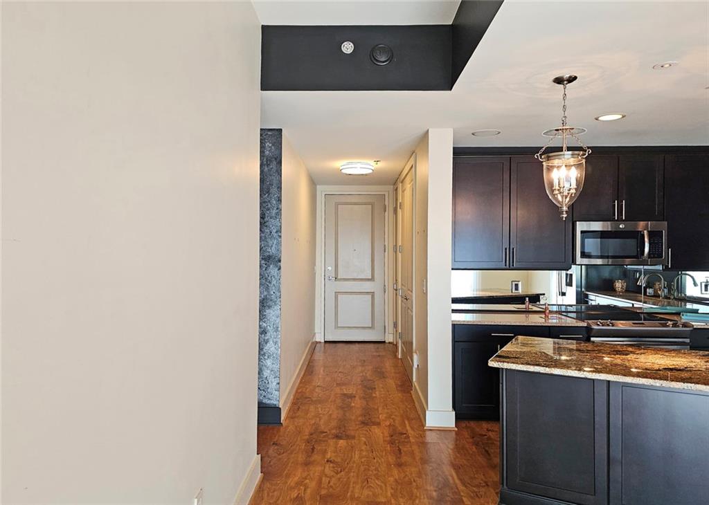 4561 Olde Perimeter Way, Unit 704 Atlanta, GA 30346 - Photo 4 of 45 a kitchen with stainless steel appliances granite countertop a sink and a stove top oven