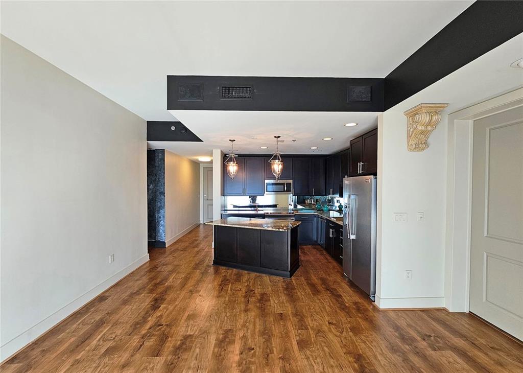 4561 Olde Perimeter Way, Unit 704 Atlanta, GA 30346 - Photo 8 of 45 a kitchen with stainless steel appliances granite countertop a refrigerator a stove and a wooden floors