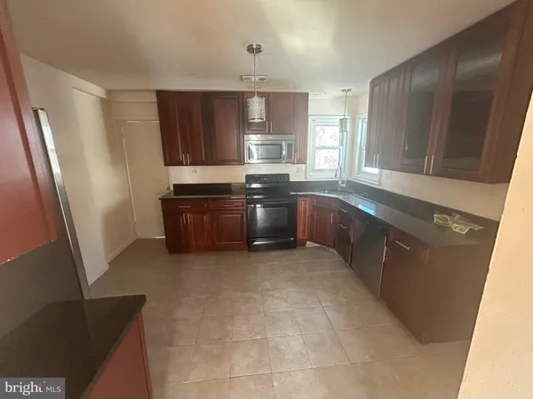 a large kitchen with stainless steel appliances granite countertop a sink stove and refrigerator