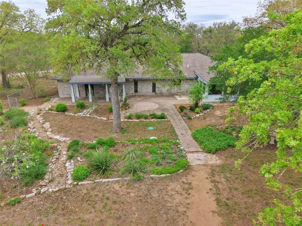a front view of a house with a yard and shrubs