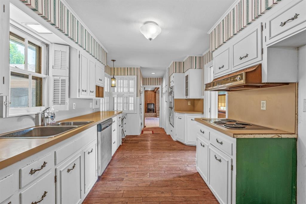 1222 Kentucky Street Graham, TX 76450 - Photo 12 of 37 a large kitchen with stainless steel appliances granite countertop a stove and a sink