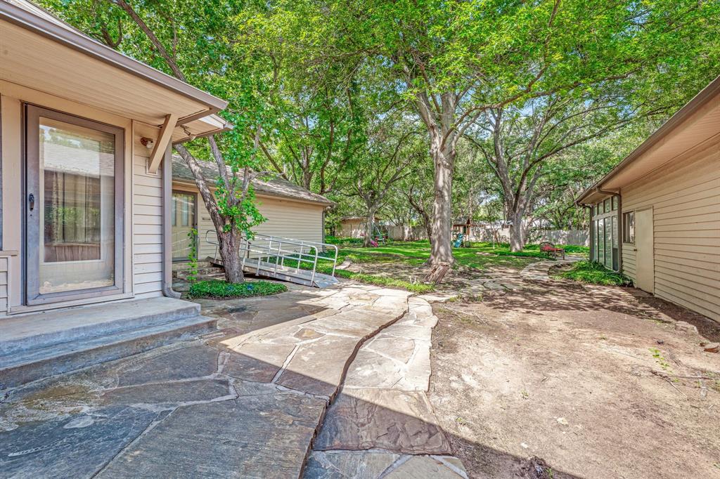 1222 Kentucky Street Graham, TX 76450 - Photo 24 of 37 a view of a house with a yard and large tree
