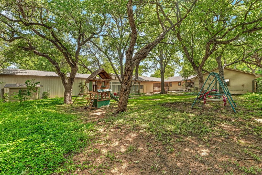 1222 Kentucky Street Graham, TX 76450 - Photo 26 of 37 a view of a house with yard and a tree
