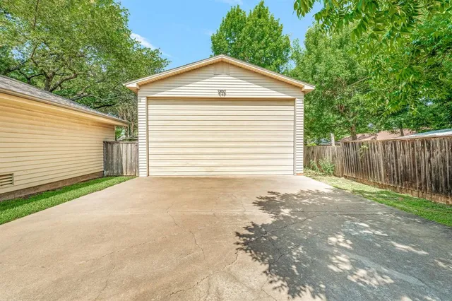 an aerial view of residential houses with outdoor space and trees